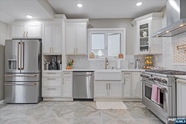 a kitchen with stainless steel appliances a stove a sink and a refrigerator