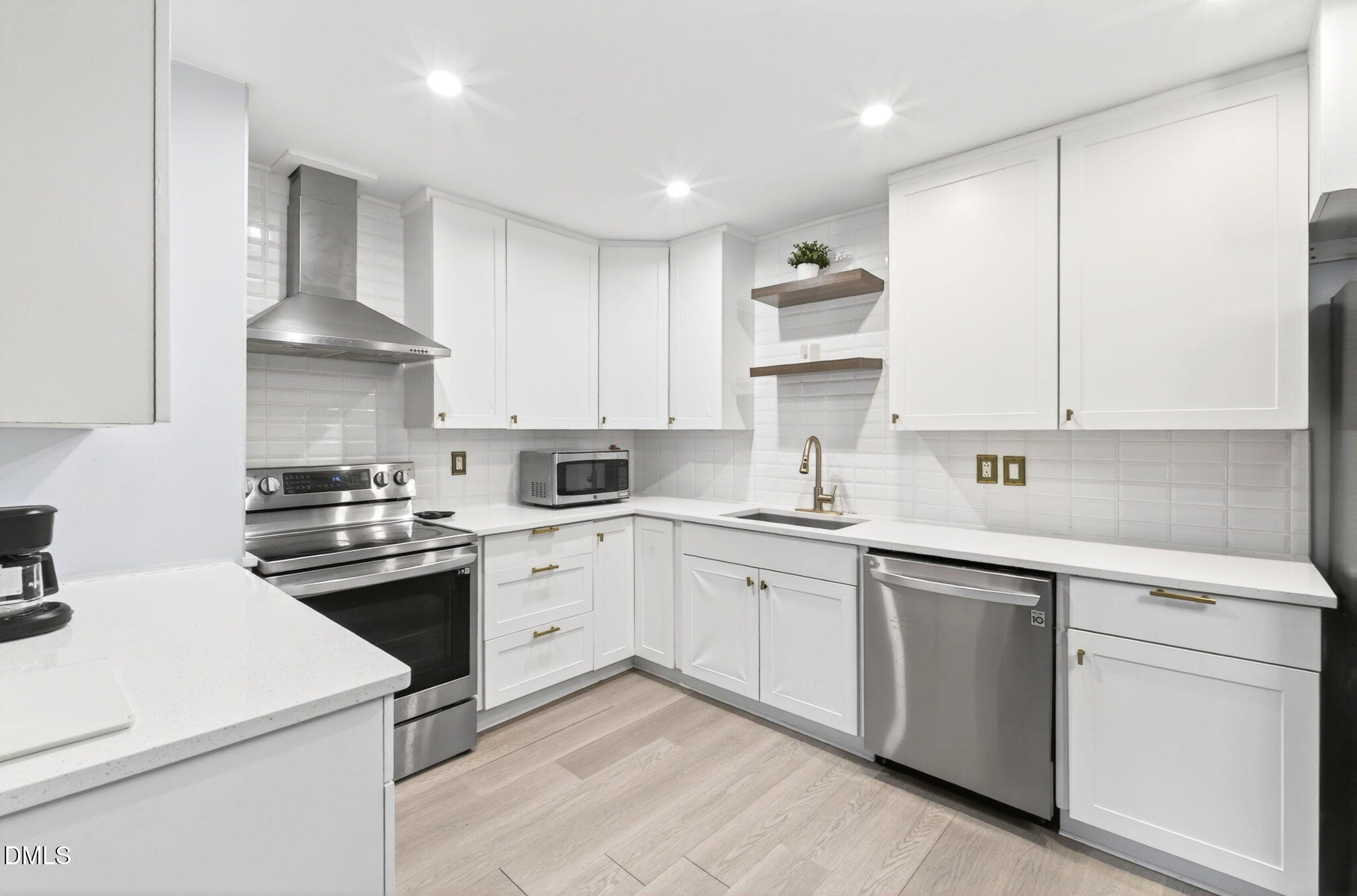 1809 Martin Luther King Jr Boulevard Raleigh, NC 27610 - Photo 8 of 26 a kitchen with white cabinets stainless steel appliances and sink