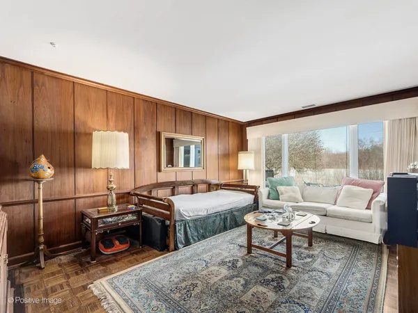 a bedroom with furniture and a large window