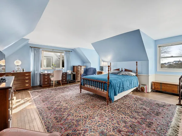 a bedroom with a bed a table and chair