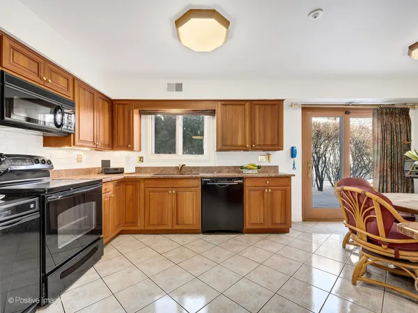 a kitchen with stainless steel appliances granite countertop a stove top oven a sink dishwasher a dining table and chairs with wooden floor