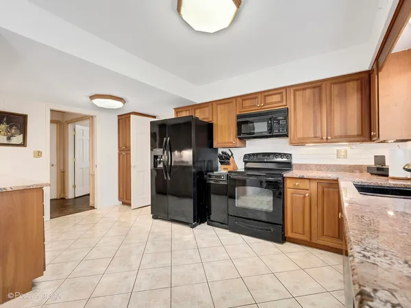 a kitchen with stainless steel appliances granite countertop a refrigerator and a stove top oven