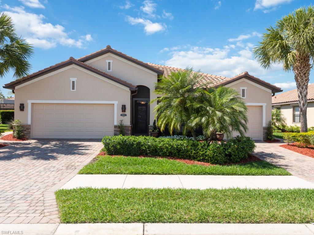 a view of a white house with a yard and potted plants