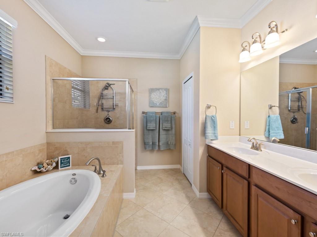 3913 Sapphire Way Naples, FL 34114 - Photo 13 of 32 a spacious bathroom with a tub a sink and mirror