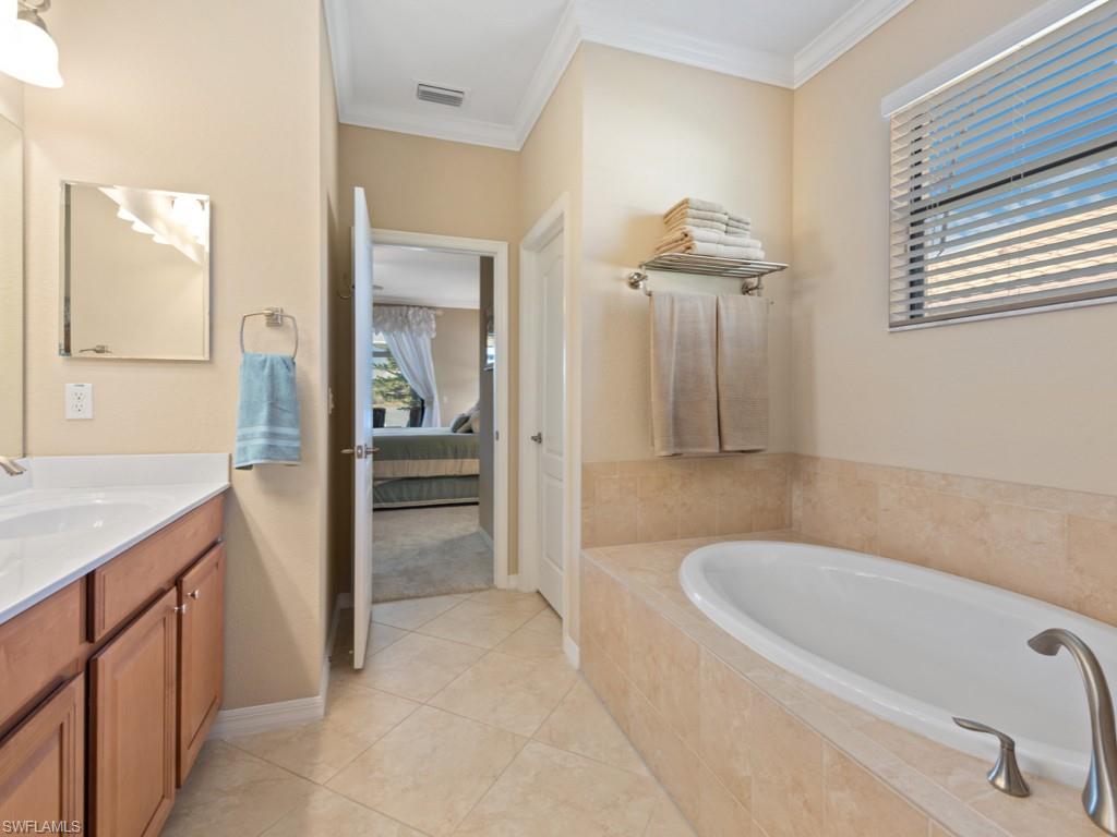 3913 Sapphire Way Naples, FL 34114 - Photo 14 of 32 a bathroom with a tub sink and mirror