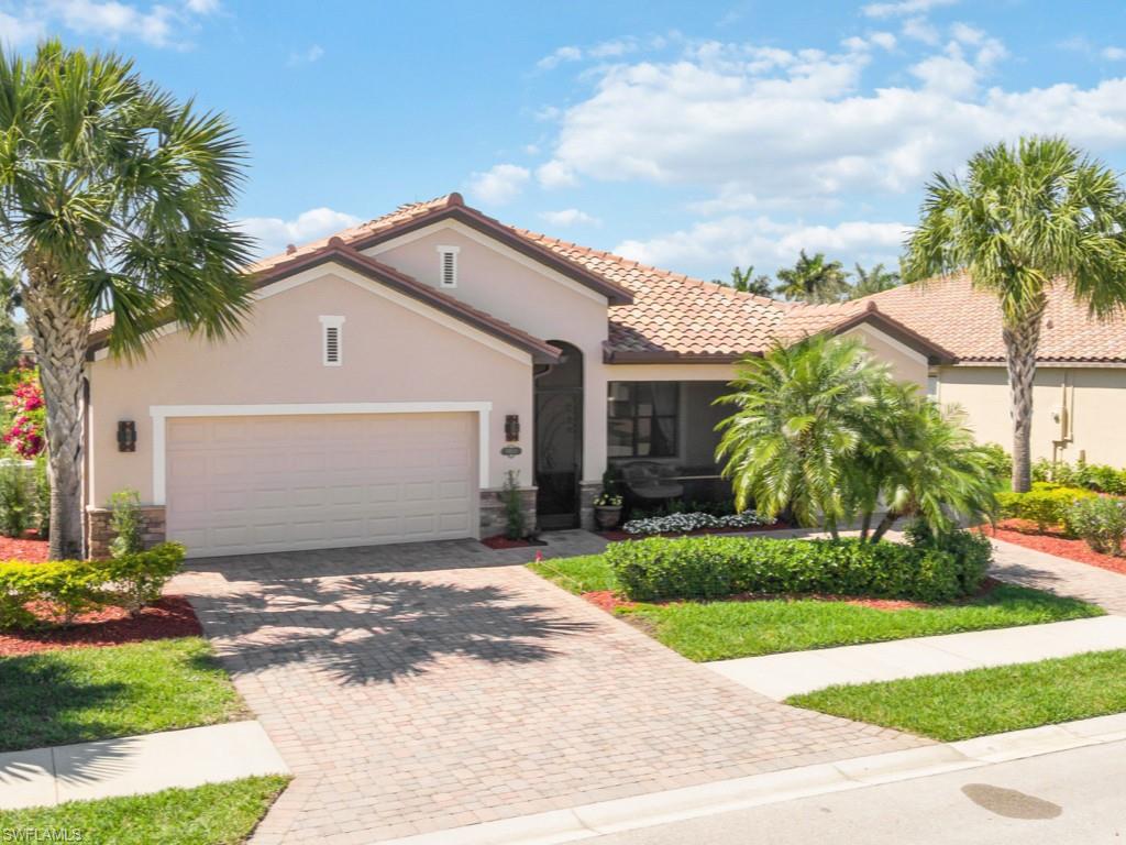 3913 Sapphire Way Naples, FL 34114 - Photo 29 of 32 a front view of a house with a garden and yard