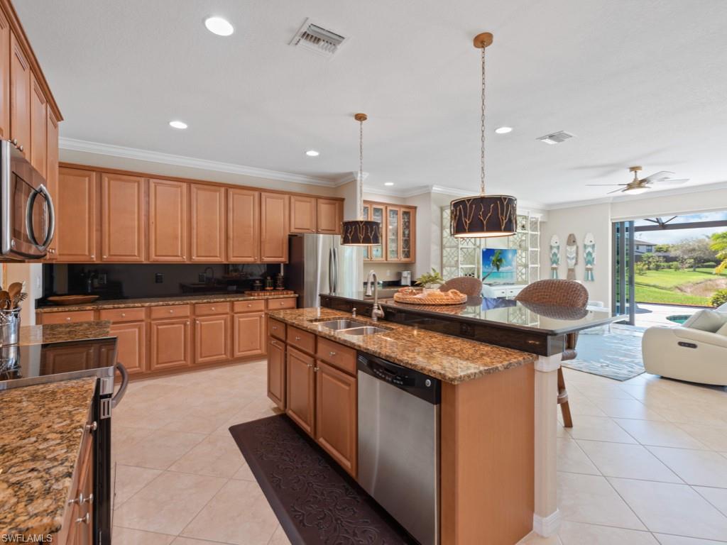 3913 Sapphire Way Naples, FL 34114 - Photo 6 of 32 a kitchen with stainless steel appliances granite countertop a stove a sink and a microwave