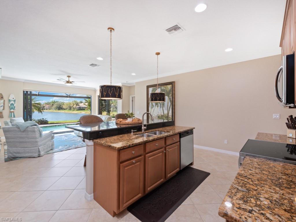 3913 Sapphire Way Naples, FL 34114 - Photo 8 of 32 a kitchen with stainless steel appliances granite countertop a stove and a sink