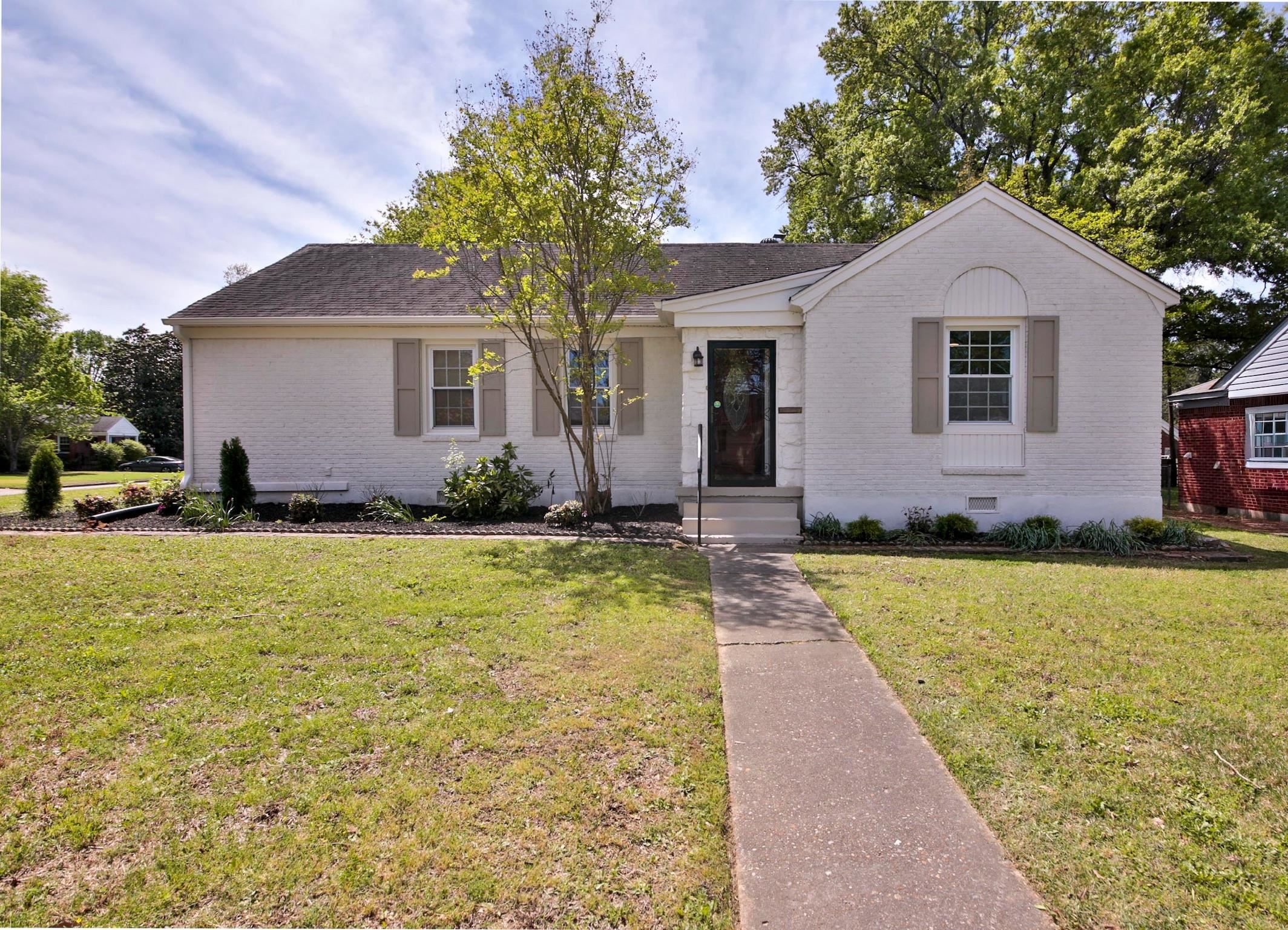a front view of house with yard and trees around