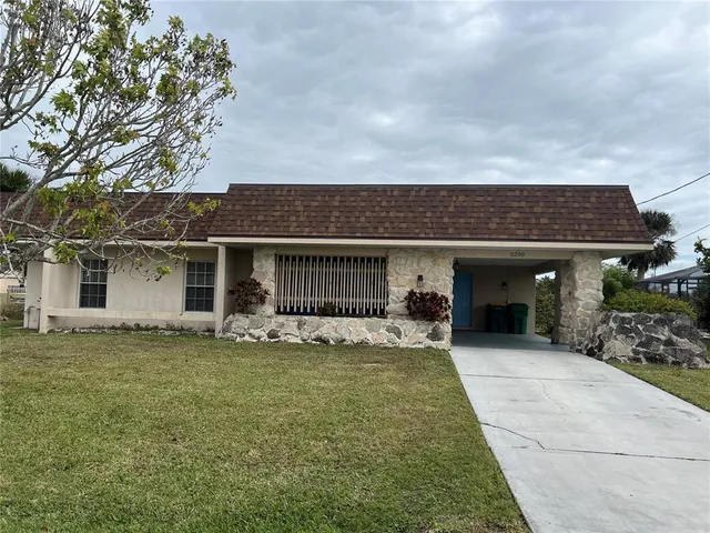 a view of a house with a yard and sitting area
