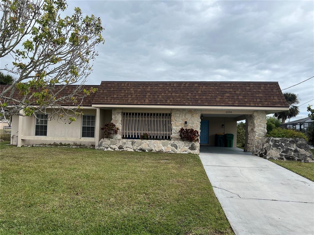 a view of a house with a yard and sitting area
