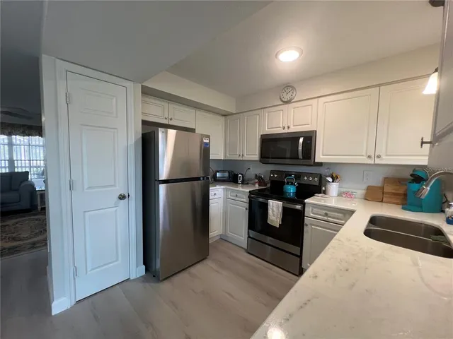 a kitchen with stainless steel appliances granite countertop a refrigerator a stove top oven a sink and dishwasher