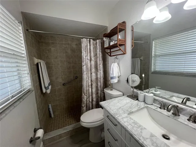 a bathroom with a granite countertop sink toilet and shower