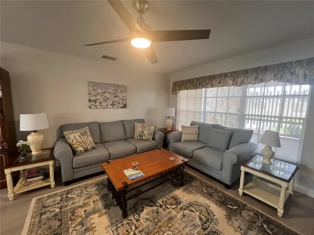 a living room with furniture a rug and a window