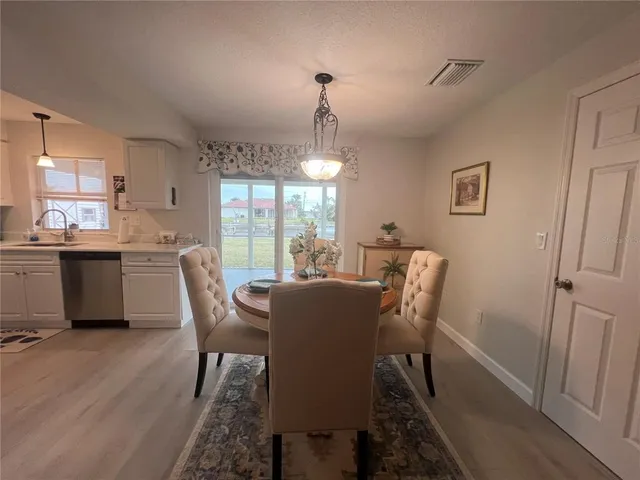a dining room with furniture a chandelier and wooden floor