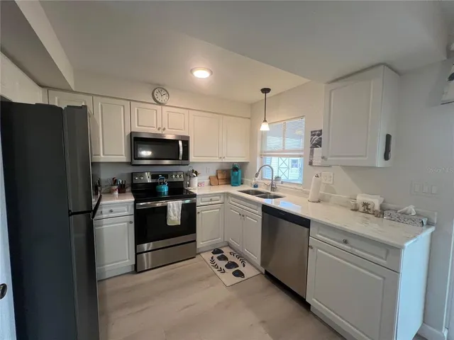 a kitchen with a sink stainless steel appliances and cabinets