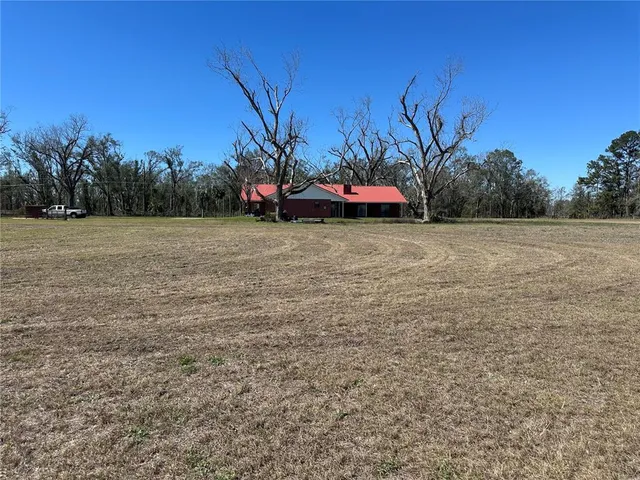 a view of a field with some trees in front of it