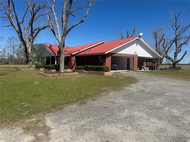 a front view of a house with a yard and trees
