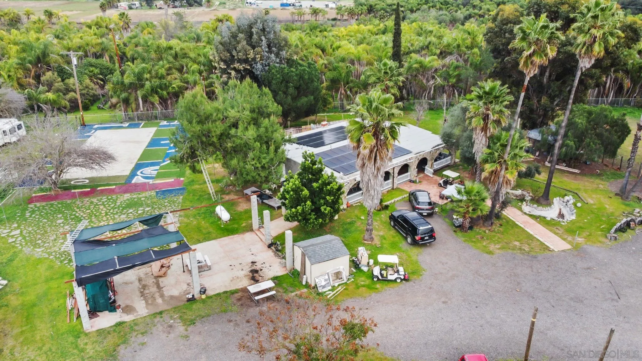an aerial view of a house with a yard basket ball court and outdoor seating