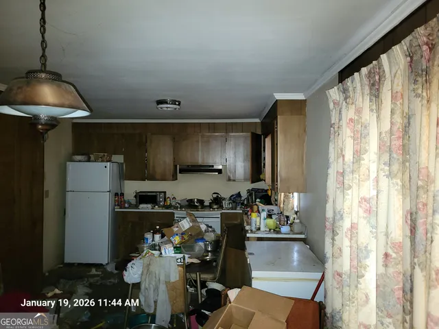 a kitchen with refrigerator and cabinets