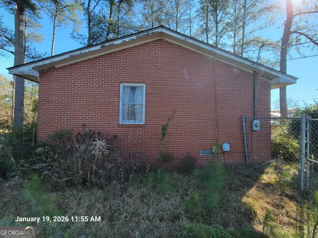 a front view of house with yard and trees in the background