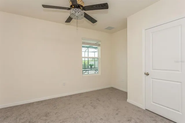an empty room with a window and a fan