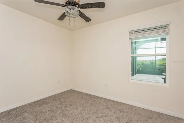 an empty room with a ceiling fan and a window