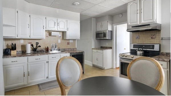 a kitchen with stainless steel appliances granite countertop a sink a stove cabinets and a refrigerator