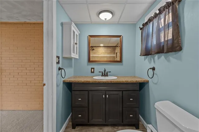a bathroom with a sink a toilet and mirror