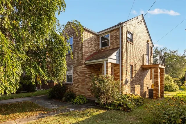 front view of a house with a yard and potted plants