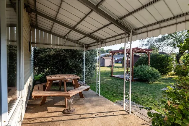 a patio with table and chairs and potted plants