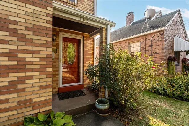 a view of front door of house with potted plants