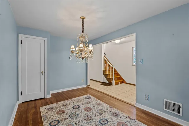 a view of a room with wooden floor and a chandelier