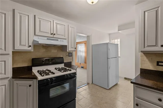 a kitchen with stainless steel appliances granite countertop a stove refrigerator and cabinets