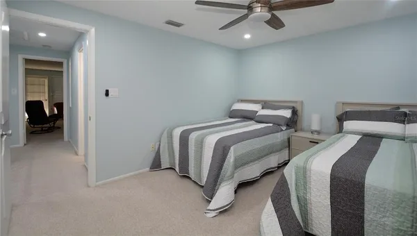 a bedroom with two beds and a ceiling fan