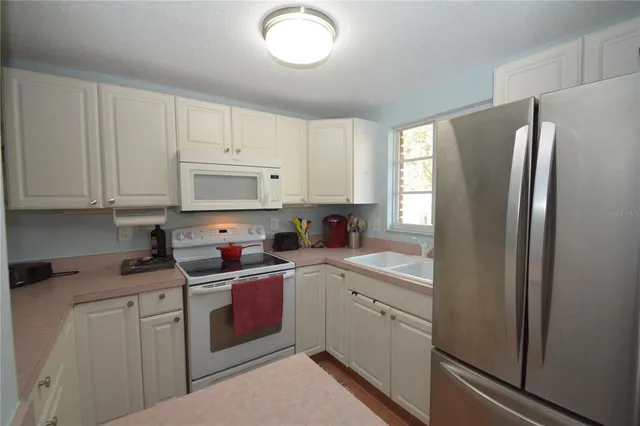 a kitchen with stainless steel appliances granite countertop a refrigerator sink and cabinets