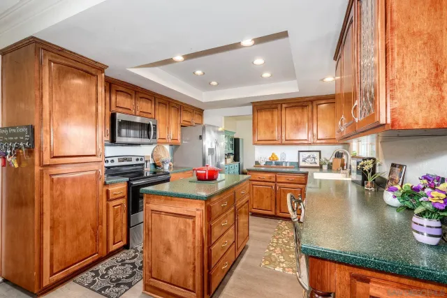 a kitchen with stainless steel appliances granite countertop a refrigerator a stove top oven a sink and dishwasher