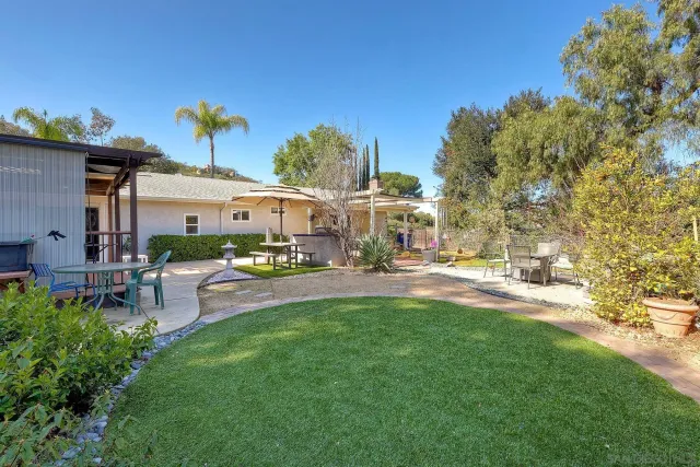 a view of a patio with table and chairs and potted plants