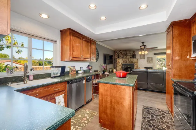 a kitchen view with wooden floor and stainless steel appliances