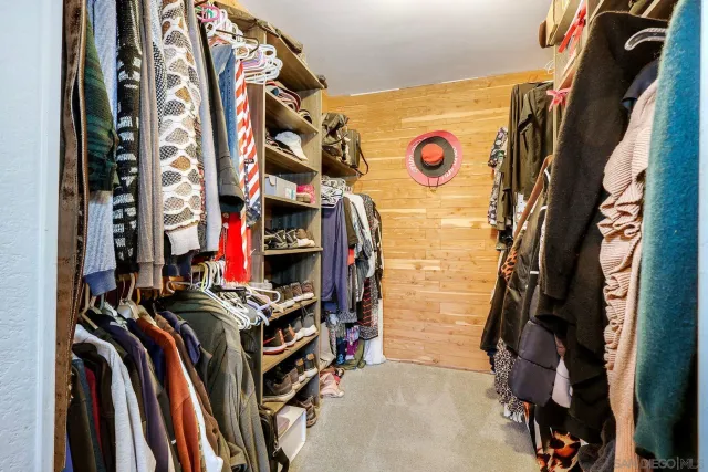 a view of walk in closet with clothes