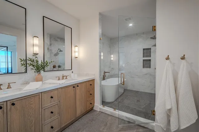 a spacious bathroom with a double vanity sink a mirror and a shower