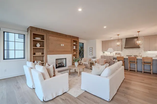 a living room with furniture fireplace and a large window