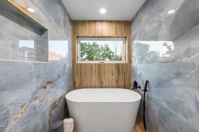 a bathroom with a sink a bathtub and window