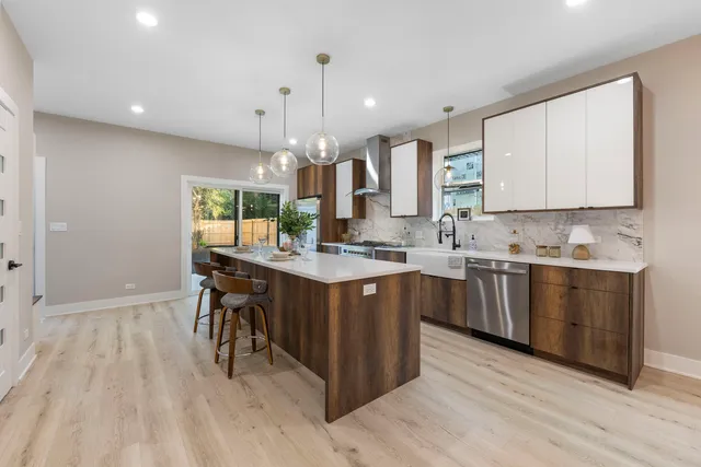 a kitchen with kitchen island granite countertop a sink cabinets and wooden floor