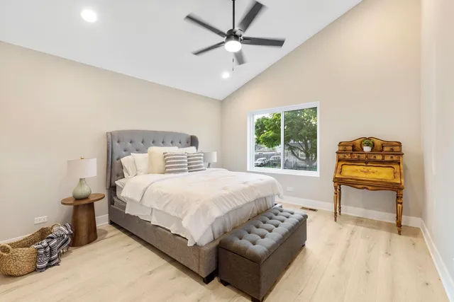 a bedroom with a bed a table and a chandelier