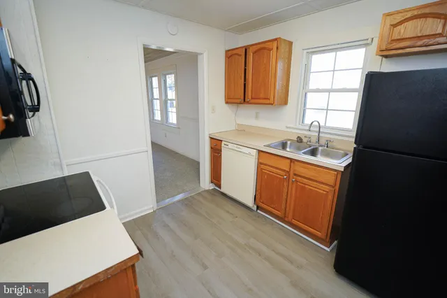 a kitchen with granite countertop white cabinets and black appliances