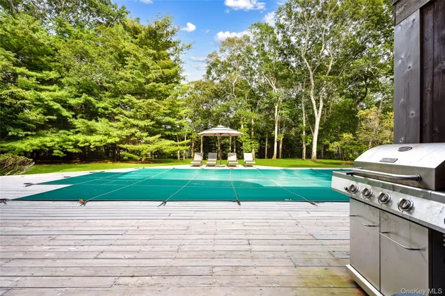 a view of a table and chairs on the deck in the backyard