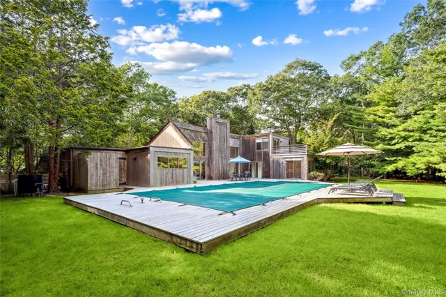 a view of a backyard with wooden floor and large trees