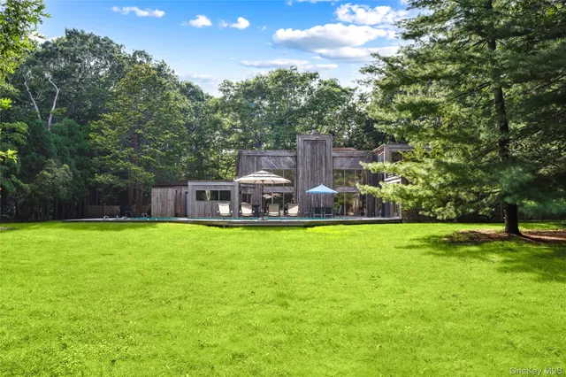 a front view of a house with a yard and trees