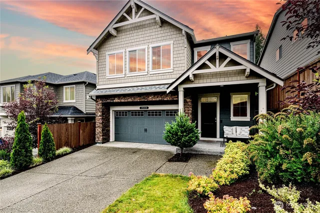 a front view of a house with a yard and potted plants